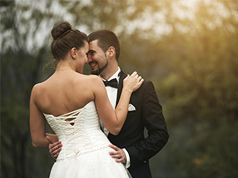 Casal sob um véu com fumaça e flores, simbolizando a restauração e união